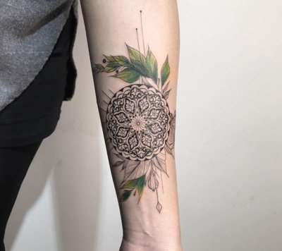  Tatouage mandala sur le bras avec une partie qui représente des feuilles vertes